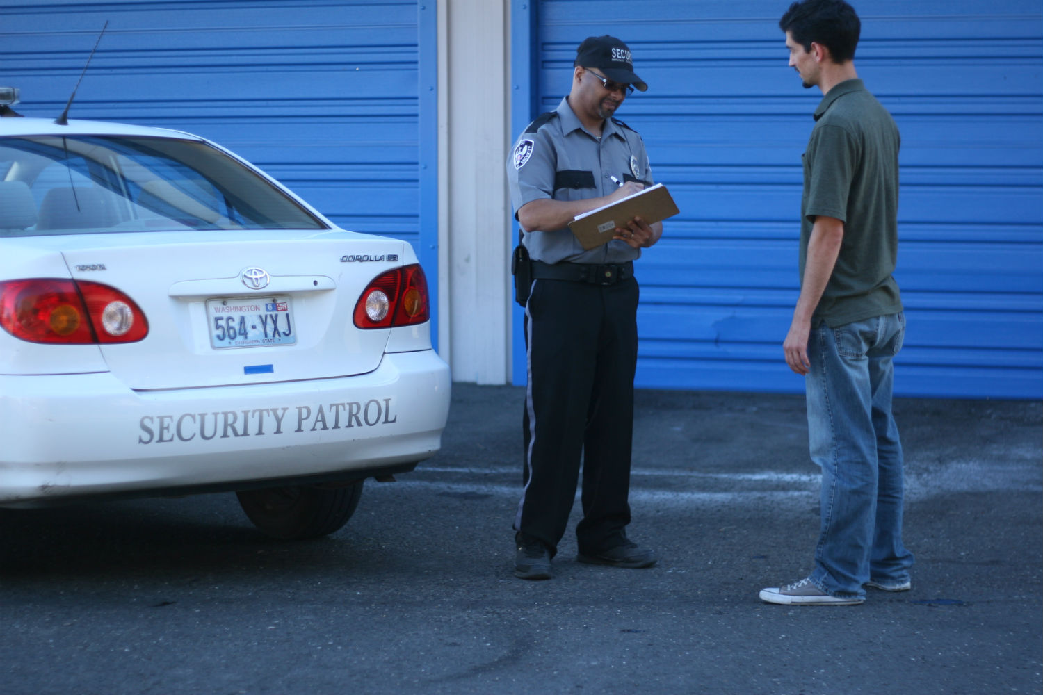 A man standing next to a white car.